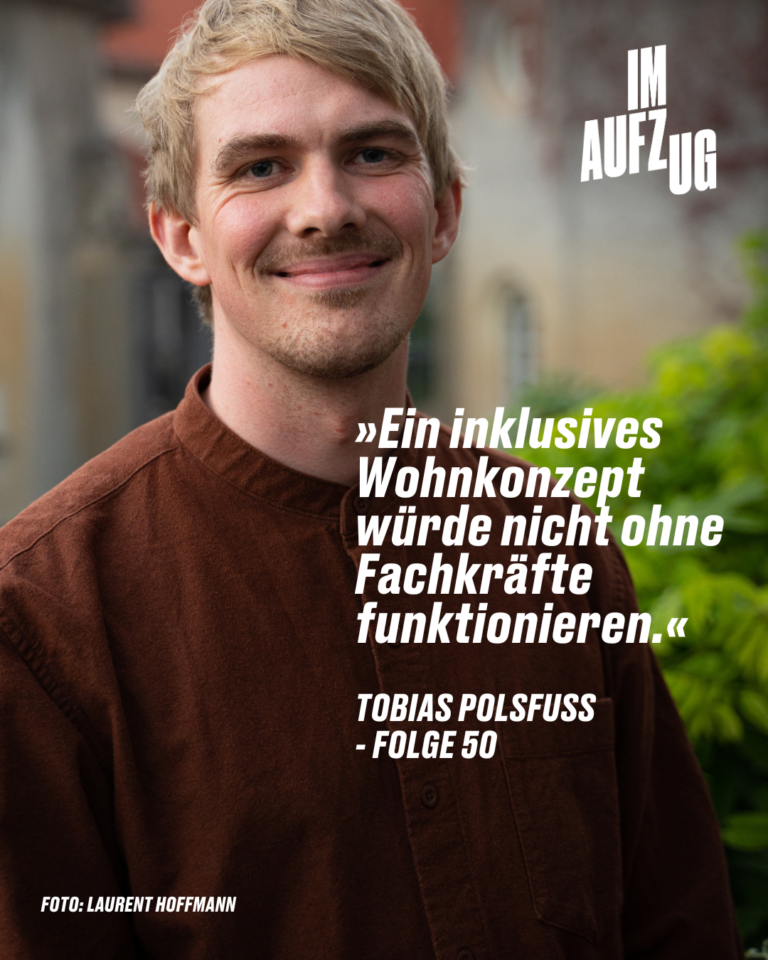 ChatGPT ALT-Text: "Porträt von Tobias Polsfuß, einem jungen Mann mit kurzen blonden Haaren und einem sanften Lächeln. Er trägt ein dunkelbraunes Cordhemd und blickt direkt in die Kamera. Im Hintergrund ist eine unscharfe urbane Szene. Über ihm ist in großen weißen Buchstaben "IM AUFZUG" zu lesen, und darunter steht ein Zitat: "Ein inklusives Wohnkonzept würde nicht ohne Fachkräfte funktionieren." – TOBIAS POLSFUSS - FOLGE 50. Am unteren Bildrand wird das Foto Laurent Hoffmann zugeschrieben."