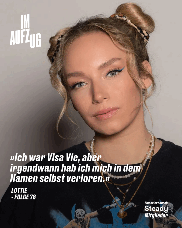Porträt von Lottie mit zwei hochgesteckten Dutt-Frisuren, hellblondem Haar, dezentem Make-up und auffälligem blauen Eyeliner. Sie trägt mehrere Perlen- und Gliederketten sowie ein schwarzes T-Shirt mit einer Comic-Illustration. Links oben steht das weiße Logo „IM AUFZUG“. Darunter ist ein Zitat in weißer Schrift zu lesen: „Ich war Visa Vie, aber irgendwann hab ich mich in dem Namen selbst verloren.“ – Lottie, Folge 78 Unten rechts: „Finanziert durch Steady Mitglieder“. Das Bild bewirbt eine neue Podcastfolge aus der Reihe „Im Aufzug“.