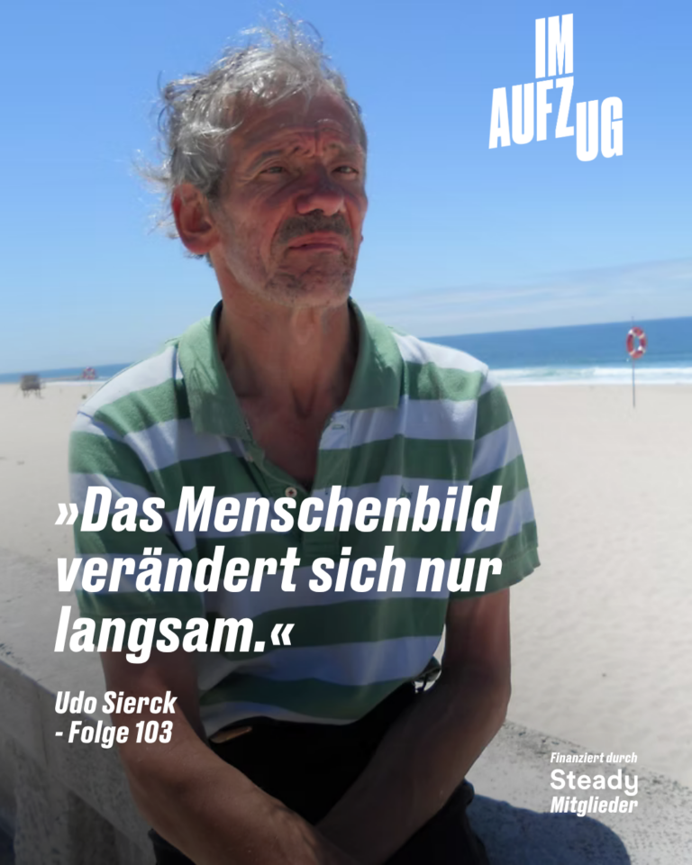Podcast-Grafik „Im Aufzug". Ein älterer Mann mit grauem, leicht zerzaustem Haar und Bartstoppeln sitzt vor einem Strand mit blauem Himmel und Meereshorizont. Er trägt ein grün-weiß gestreiftes Poloshirt und schaut leicht nach oben in die Ferne. Im Hintergrund ist ein roter Rettungsring zu sehen. Im unteren Bereich des Bildes steht in großer weißer Kursivschrift: »Das Menschenbild verändert sich nur langsam.« Darunter in kleinerer kursiver Schrift: „Udo Sierck – Folge 103". Oben rechts das Podcast-Logo „Im Aufzug". Unten rechts: „Finanziert durch Steady Mitglieder".